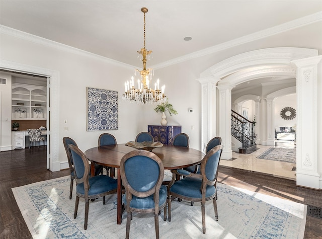 dining area featuring crown molding, dark wood-type flooring, an inviting chandelier, decorative columns, and built in shelves