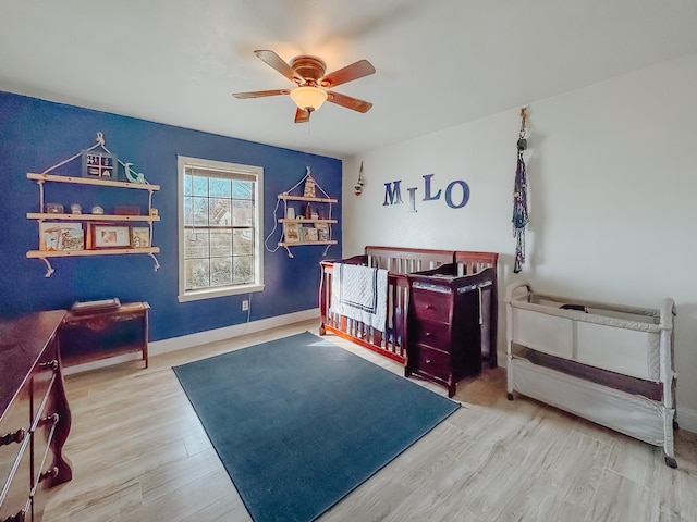 bedroom with ceiling fan, wood finished floors, and baseboards