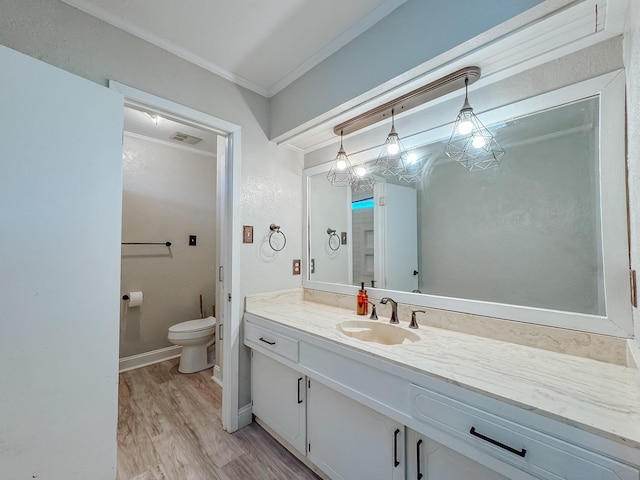 bathroom with toilet, wood finished floors, vanity, baseboards, and ornamental molding