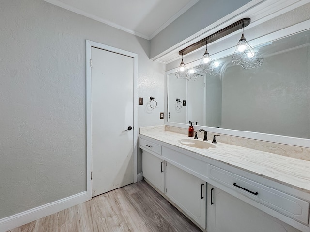 bathroom with hardwood / wood-style flooring, crown molding, and vanity