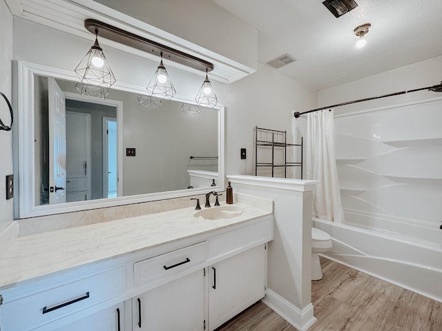 bathroom with toilet, shower / tub combo, wood finished floors, visible vents, and vanity