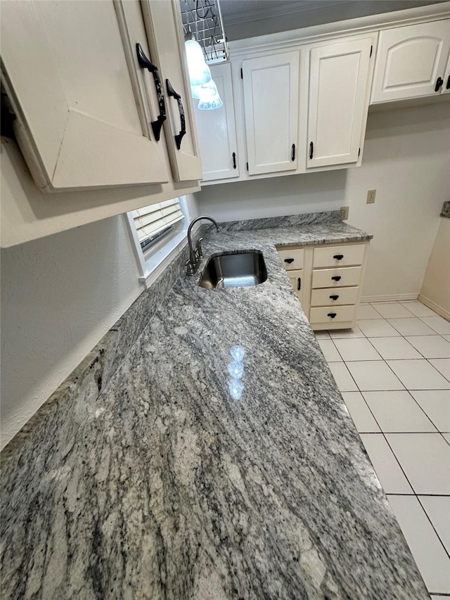 interior details featuring dark stone countertops, sink, and white cabinets