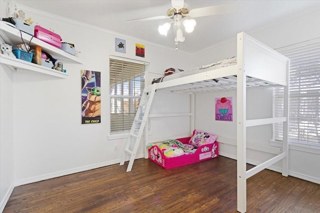 bedroom with crown molding, dark wood-type flooring, and ceiling fan