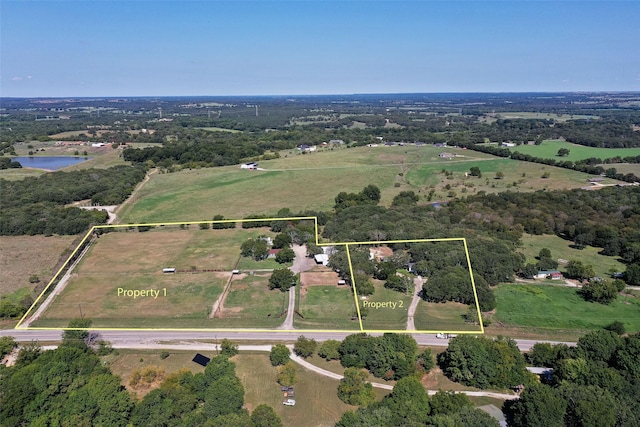 birds eye view of property featuring a water view and a rural view