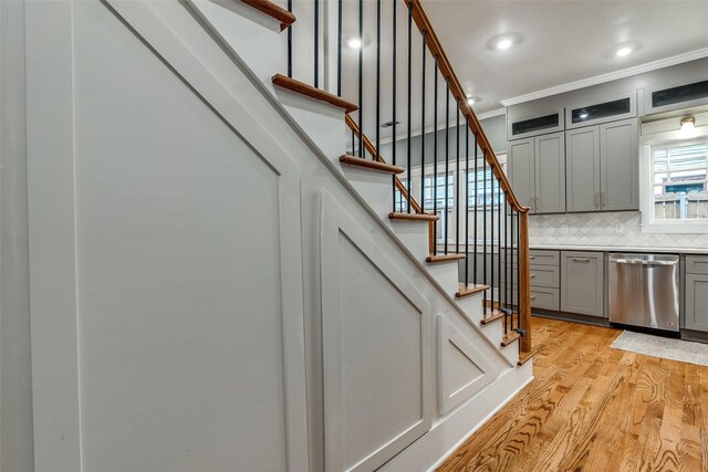 stairway featuring hardwood / wood-style flooring and ornamental molding