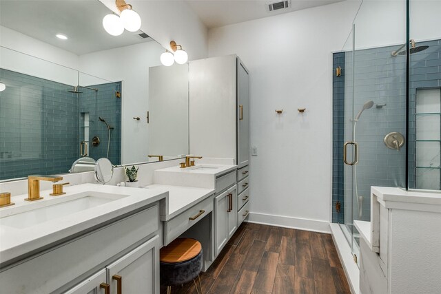 bathroom with hardwood / wood-style flooring, vanity, and a shower with shower door