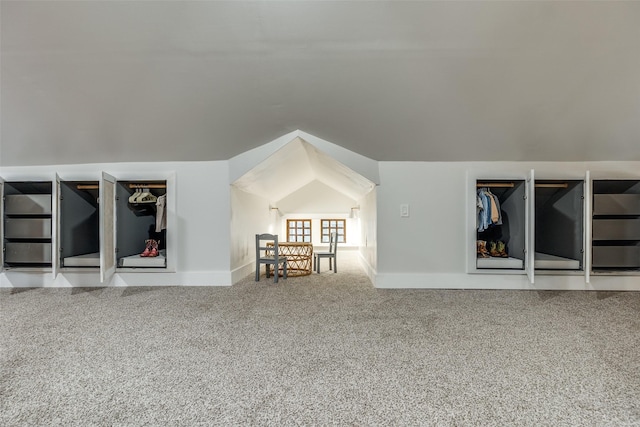 unfurnished living room with vaulted ceiling and carpet flooring