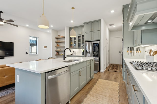 kitchen featuring extractor fan, gray cabinetry, a sink, open floor plan, and appliances with stainless steel finishes