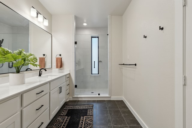 bathroom featuring a stall shower, vanity, baseboards, and tile patterned floors