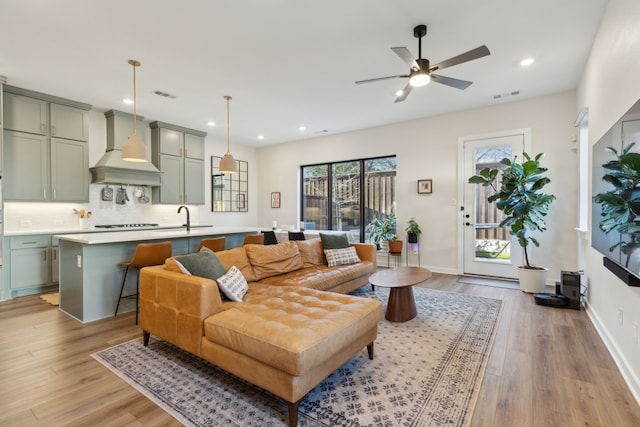 living room featuring baseboards, visible vents, and light wood-style floors