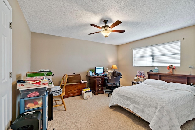 carpeted bedroom with ceiling fan and a textured ceiling