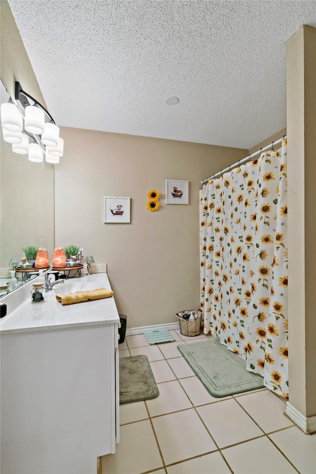 bathroom featuring tile patterned floors, vanity, a textured ceiling, and a notable chandelier