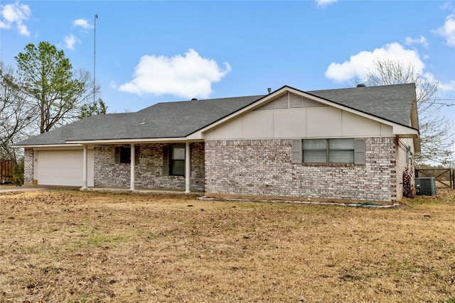 ranch-style home with cooling unit, a garage, and a front lawn