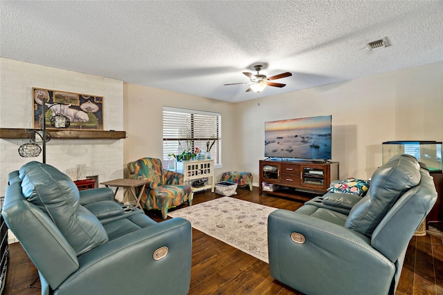 living room featuring a fireplace, dark wood-type flooring, a textured ceiling, and ceiling fan