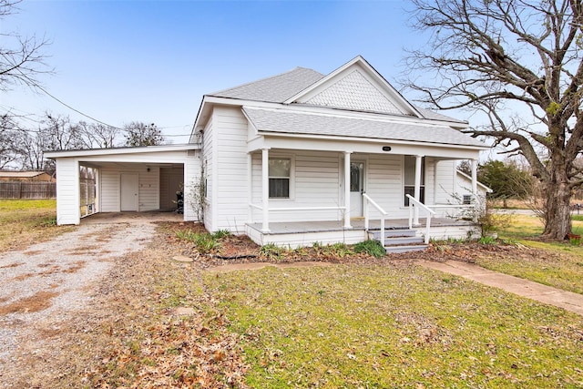 view of front facade featuring a front yard, a carport, and covered porch