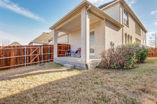 back of house featuring a patio and a yard