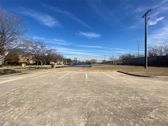 view of parking / parking lot featuring a playground