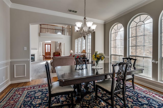 dining room with an inviting chandelier, ornamental molding, and hardwood / wood-style floors