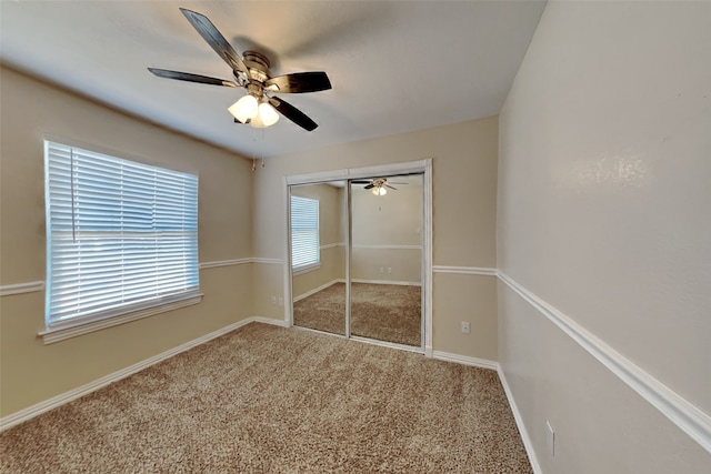 unfurnished bedroom with carpet flooring, ceiling fan, and a closet