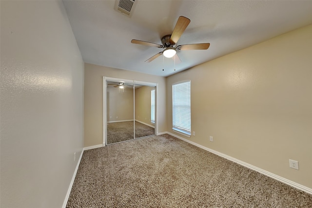 unfurnished bedroom featuring ceiling fan, carpet floors, and a closet