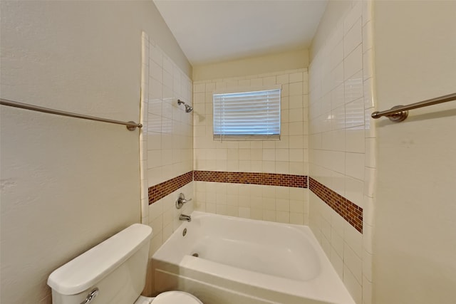 bathroom with tiled shower / bath and toilet