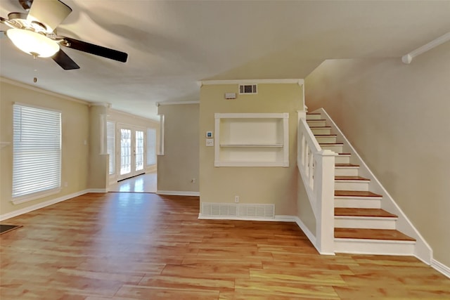 unfurnished living room featuring ceiling fan, ornamental molding, light hardwood / wood-style floors, and built in features