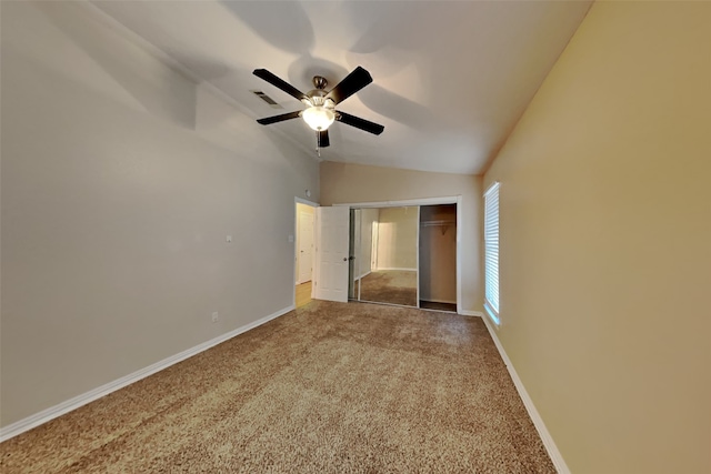 unfurnished bedroom with carpet, lofted ceiling, ceiling fan, and a closet