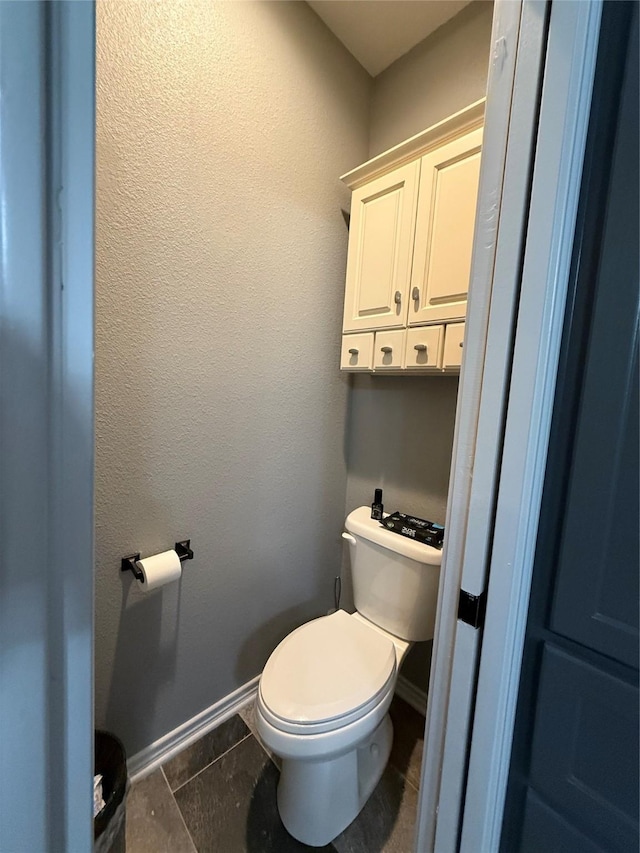 bathroom with toilet and tile patterned flooring