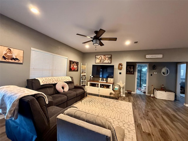 living room with dark wood-type flooring and ceiling fan