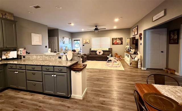 248 Mill, Emory, TX 75440 - kitchen featuring wood finished floors, gray cabinets, ceiling fan, a peninsula, and visible vents
