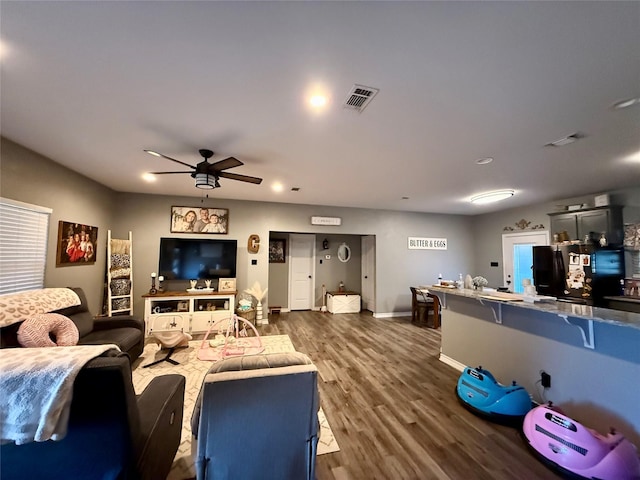 living room with ceiling fan and dark hardwood / wood-style flooring