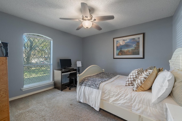 carpeted bedroom with a ceiling fan, baseboards, and a textured ceiling