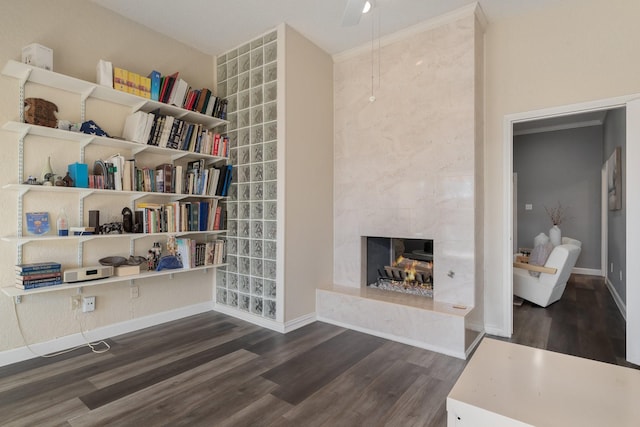 sitting room featuring wood finished floors, baseboards, and a high end fireplace