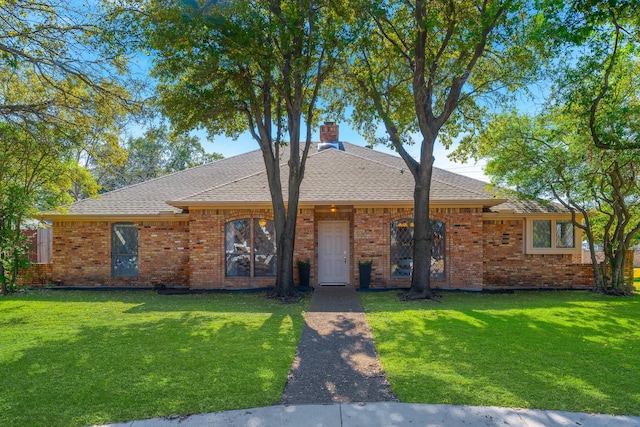 single story home with brick siding, a chimney, and a front lawn