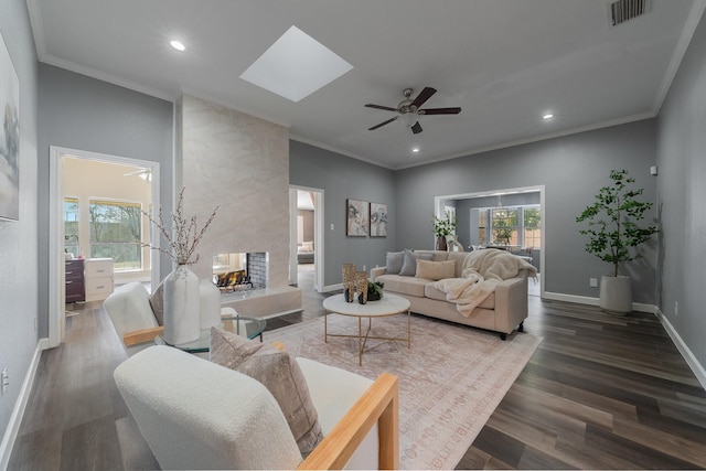 living room featuring crown molding, dark hardwood / wood-style floors, a wealth of natural light, and a skylight