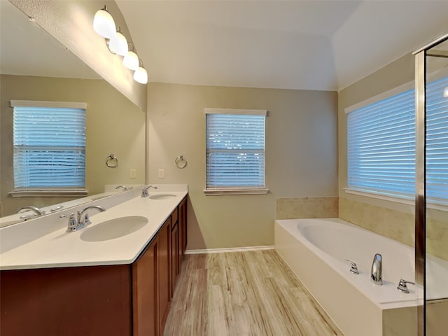 bathroom with hardwood / wood-style flooring, vanity, and a bathtub