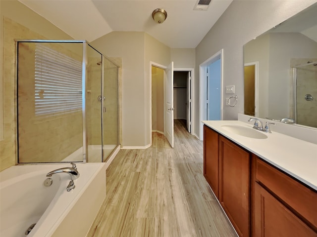 bathroom featuring vanity, hardwood / wood-style floors, vaulted ceiling, and separate shower and tub