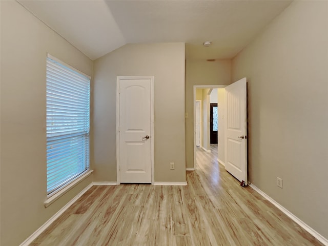 unfurnished bedroom with lofted ceiling and light hardwood / wood-style floors