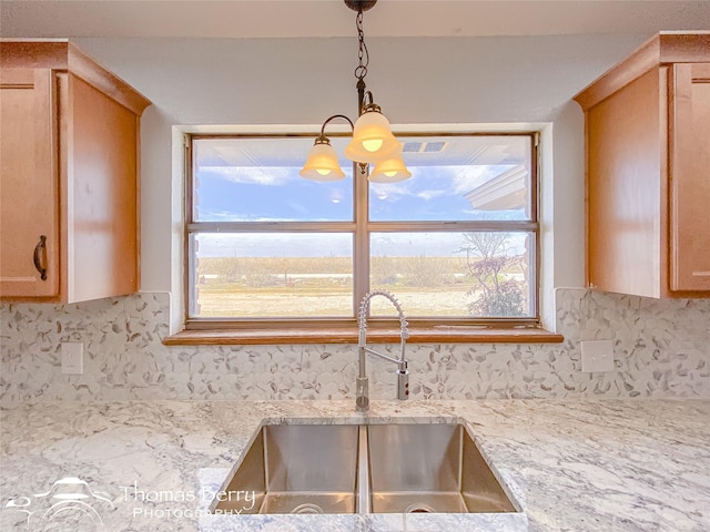 kitchen with sink, light brown cabinetry, light stone countertops, and decorative backsplash