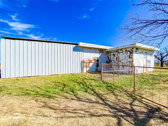 back of house featuring a yard and an outdoor structure