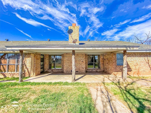 rear view of house with a patio and a lawn