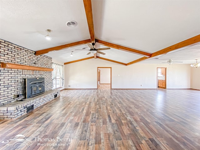 unfurnished living room featuring ceiling fan, hardwood / wood-style floors, lofted ceiling with beams, and a healthy amount of sunlight