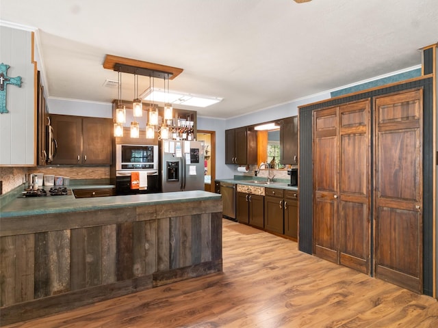 kitchen with sink, decorative light fixtures, light wood-type flooring, ornamental molding, and appliances with stainless steel finishes