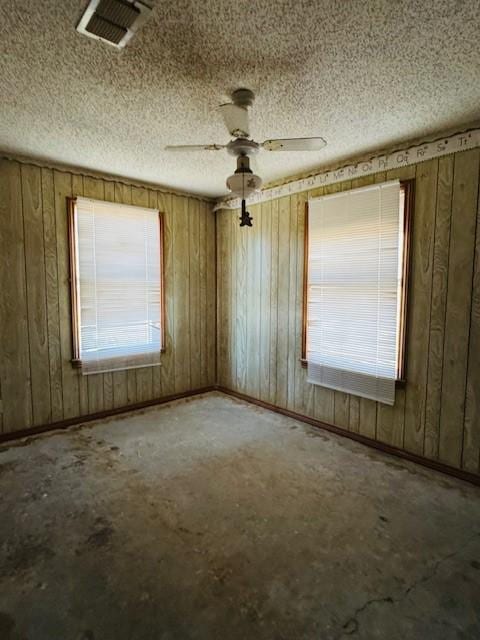 unfurnished room featuring ceiling fan, a textured ceiling, and a wealth of natural light