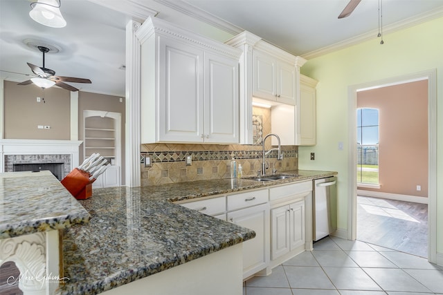 kitchen with sink, ornamental molding, stainless steel dishwasher, and white cabinets