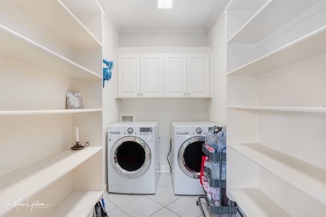 laundry area with crown molding, cabinets, washing machine and clothes dryer, and light tile patterned flooring