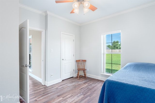 bedroom with crown molding, hardwood / wood-style floors, and ceiling fan