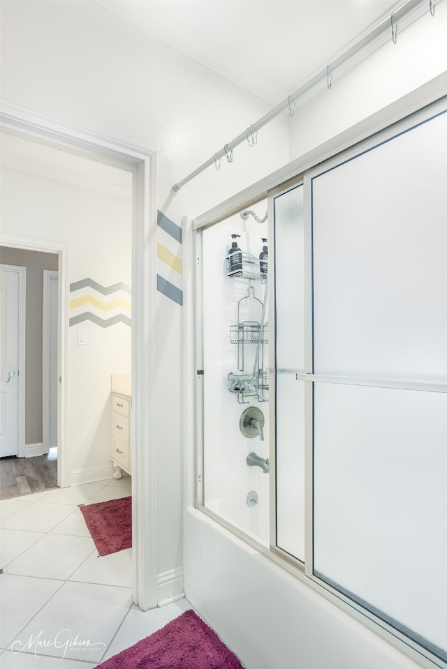 bathroom featuring enclosed tub / shower combo, tile patterned floors, and vanity