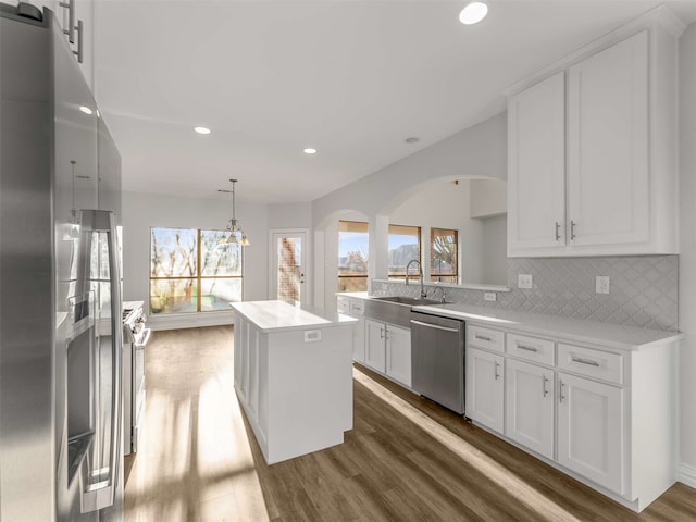 kitchen with a kitchen island, appliances with stainless steel finishes, sink, and white cabinets