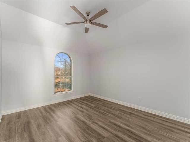 empty room featuring lofted ceiling, dark hardwood / wood-style floors, and ceiling fan